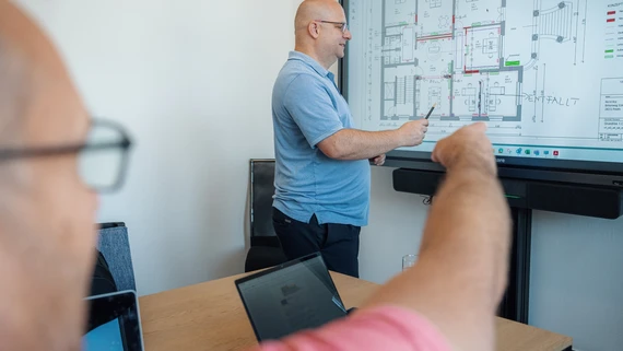 IT-Experten von Dr. Netik & Partner bei der gemeinsamen Planung am interaktiven Whiteboard.