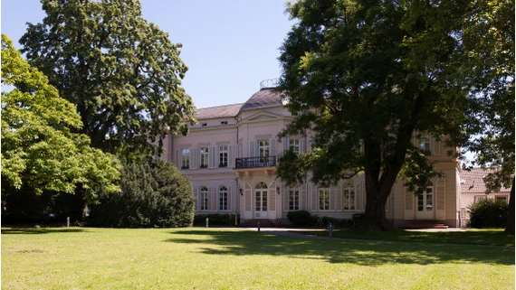 Historisches Firmengebäude von Medialine in grüner Umgebung.